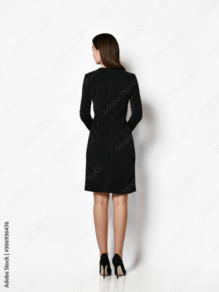 Young beautiful woman posing in new fashion long casual dark black winter dress happy smiling walking full body Young beautiful woman posing in new fashion long casual dark black winter dress happy smiling walking full body