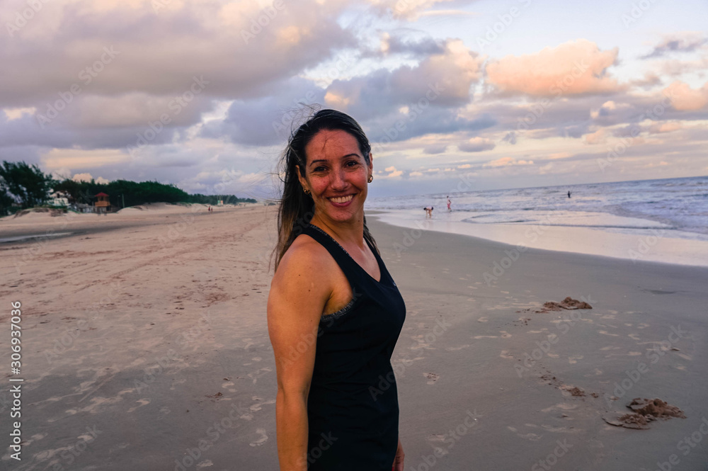 Mulher na praia com pôr do sol 