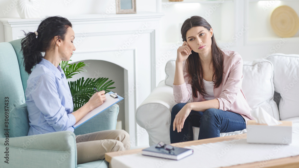 Unhappy woman visiting private psychotherapist at her private clinic Unhappy woman visiting private psychotherapist at her private clinic