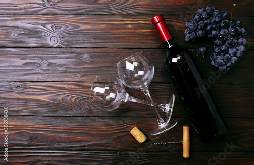 Bottle of wine and glasses on wooden background