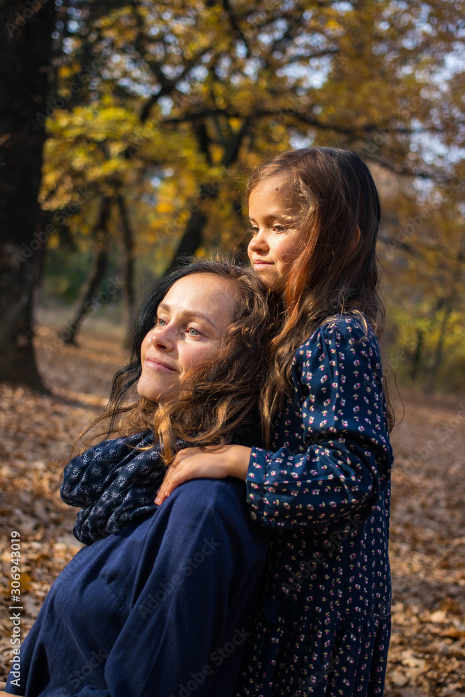 Daughter little girl hugs her mother in the forest or park. Family relationships concept Daughter little girl hugs her mother in the forest or park. Family relationships concept