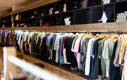 Men clothing shop, casual clothes on hangers and shelves in apparel store