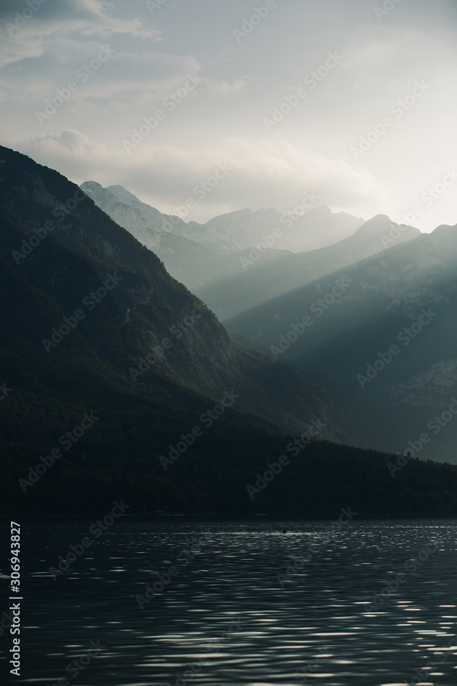 Silhouettes of mountains in the mist. Foggy mountain landscape in Triglav National Park, Slovenia. Fog covering the mountain forests. 