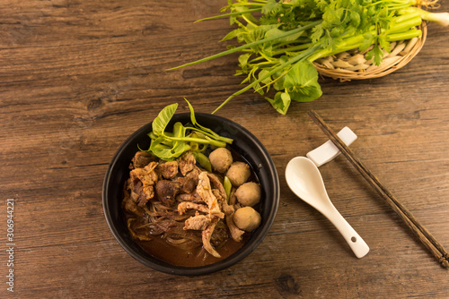 Hot and Spicy Nam Tok noodles soup with meat balls.Thai boat noodles is Street food of Thailand style, that famous noodles soup,Thai Boat noodles soup or Guay tiew reua, Rice noodles thicken soup. photo