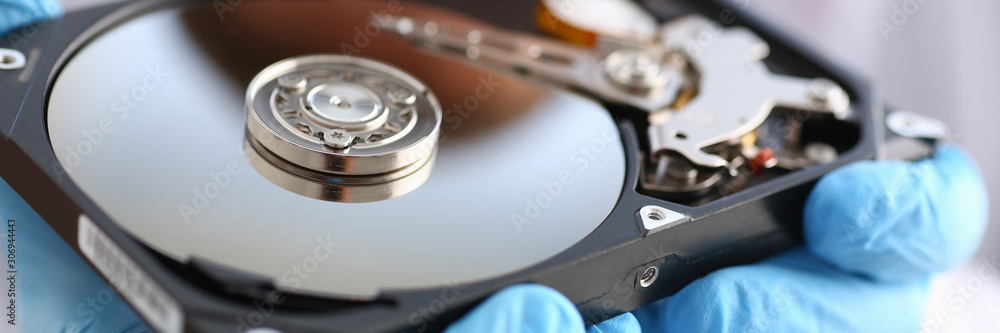 male repairman wearing blue gloves is holding a hard drive male repairman wearing blue gloves is holding a hard drive