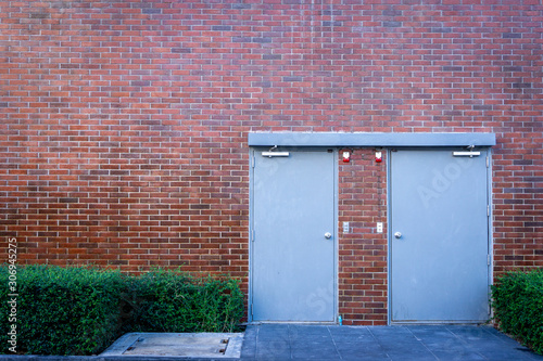 Fire exit out side of a building with a red block wall
