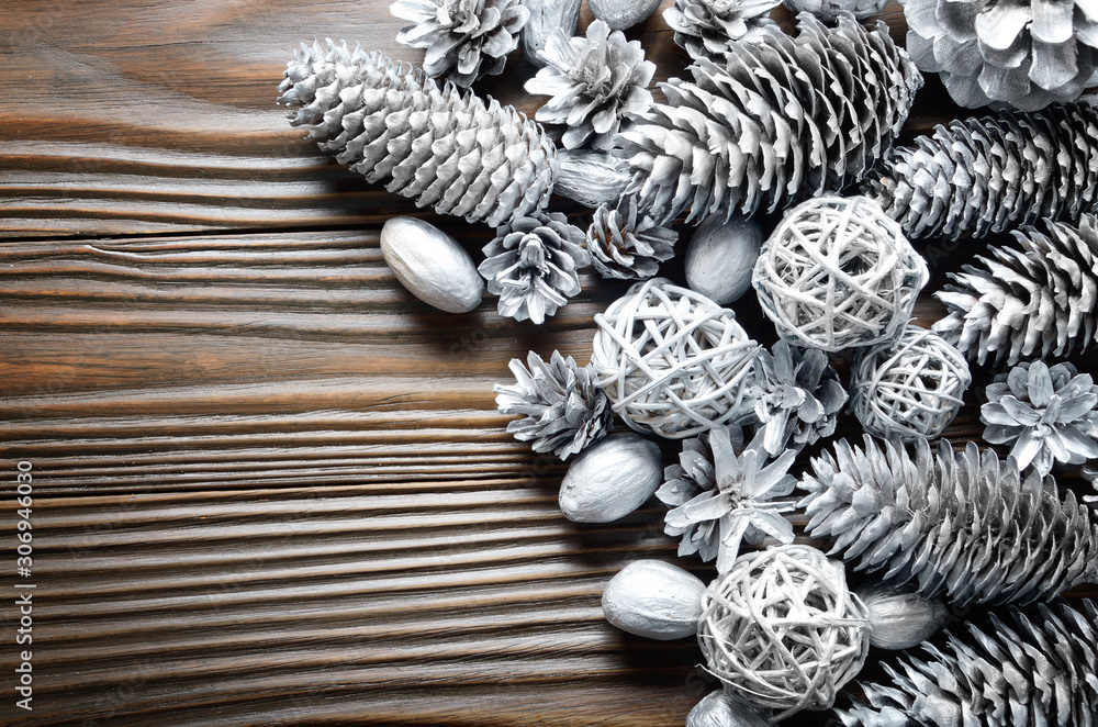 Flat lay silver background of fir and pine painted cones, nuts and wicker balls Flat lay silver background of fir and pine painted cones, nuts and wicker balls