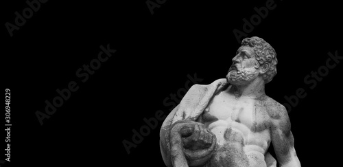 Ancient statuue of Hercules on black background photo