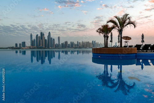 Photography Beautiful swimming pool on Dubai skyline background with reflections in the wate