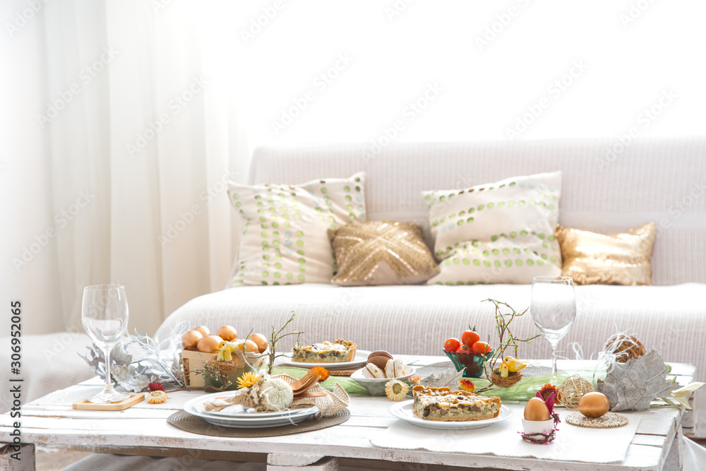 The interior of the room with a festive Easter table . The interior of the room with a festive Easter table .