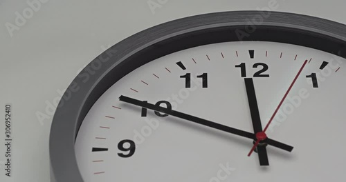 Truck shot of time-lapse gray clock with black arrows shows motion the time speed up from 11.00 p.m. and slow down to 12.00 p.m., How time flies concept.