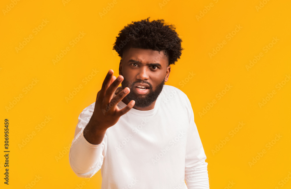 Angry black guy shouting and gesturing over orange background Angry black guy shouting and gesturing over orange background