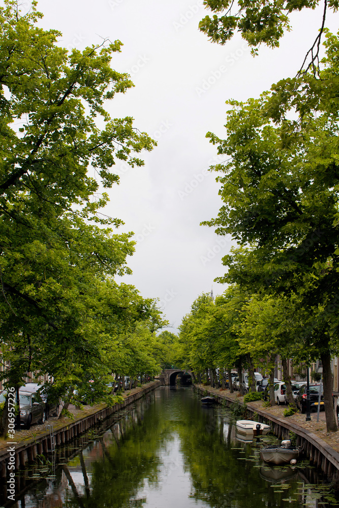 View of canal, trees and bridge in Edam. It is a town famous for its semi hard cheese in the northwest Netherlands, in the province of North Holland.
