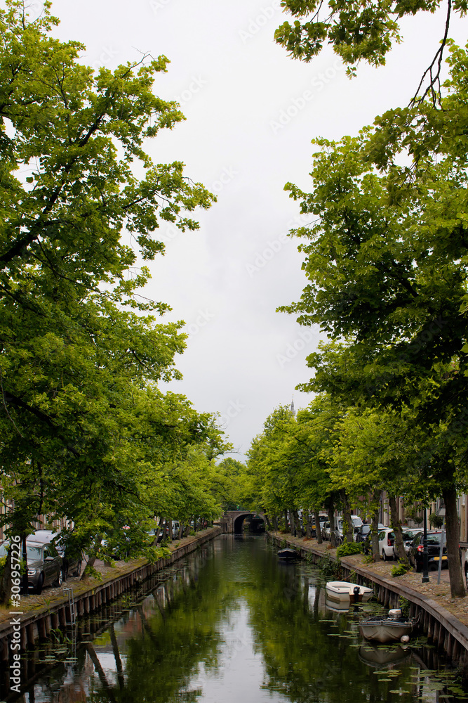 View of canal, trees and bridge in Edam. It is a town famous for its semi hard cheese in the northwest Netherlands, in the province of North Holland. View of canal, trees and bridge in Edam. It is a town famous for its semi hard cheese in the northwest Netherlands, in the province of North Holland.