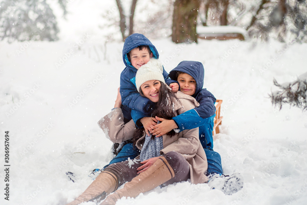 Obraz premium Beautiful family photo of mom with her two sons enjoying winter time.