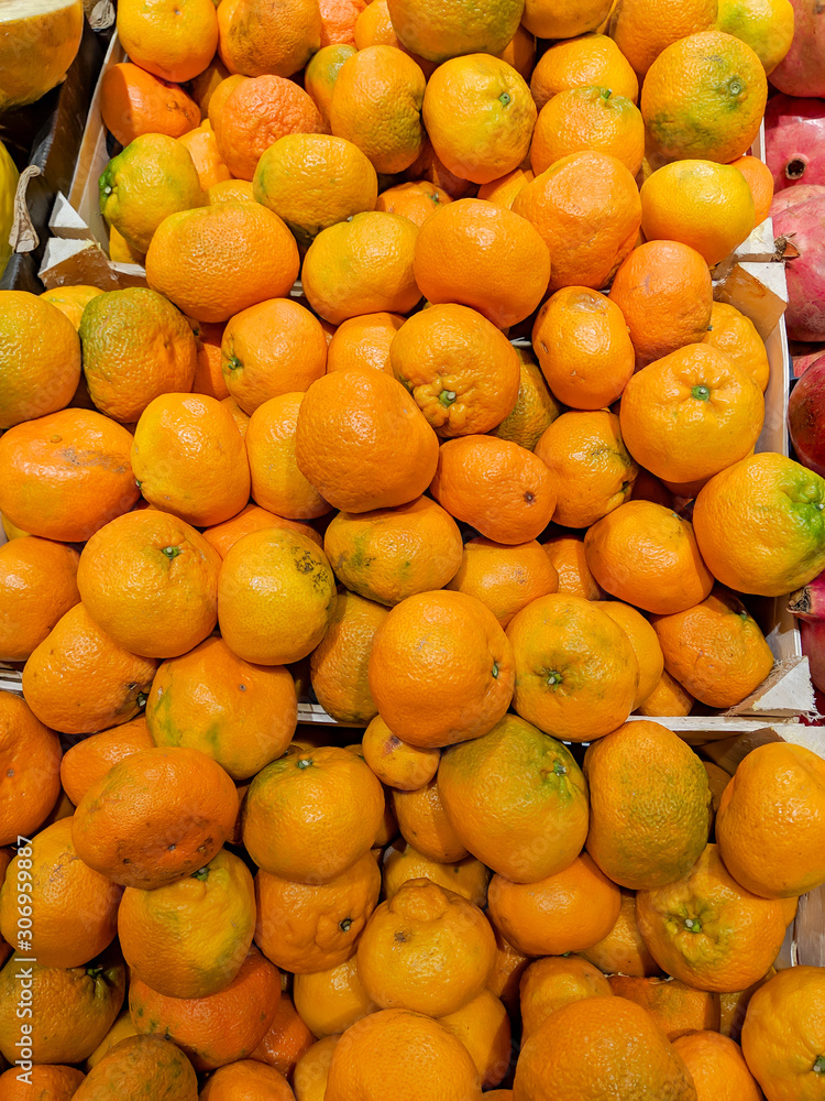 Delicious and fresh orange tangerines stacked and prepared to be sold in a supermarket shop. Juicy and very healthy snack fruit.