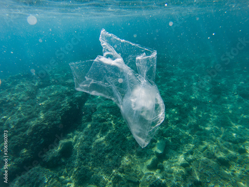 Plastic bag floating in the mediterranean sea, Catalonia, Spain. Water is polluted by single use plastics. Reuse, reduce, recycle photo