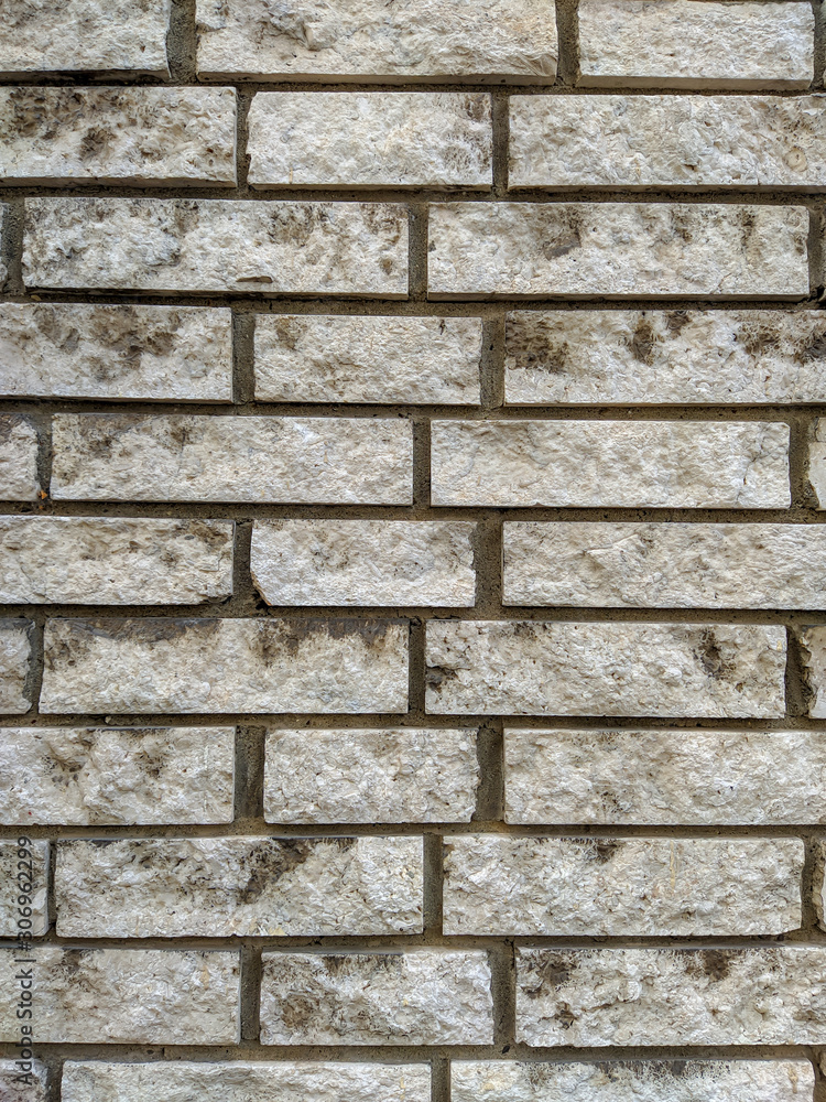 Obraz premium Old looking retro white horizontal stone rock bricks on an outdoors wall of a building