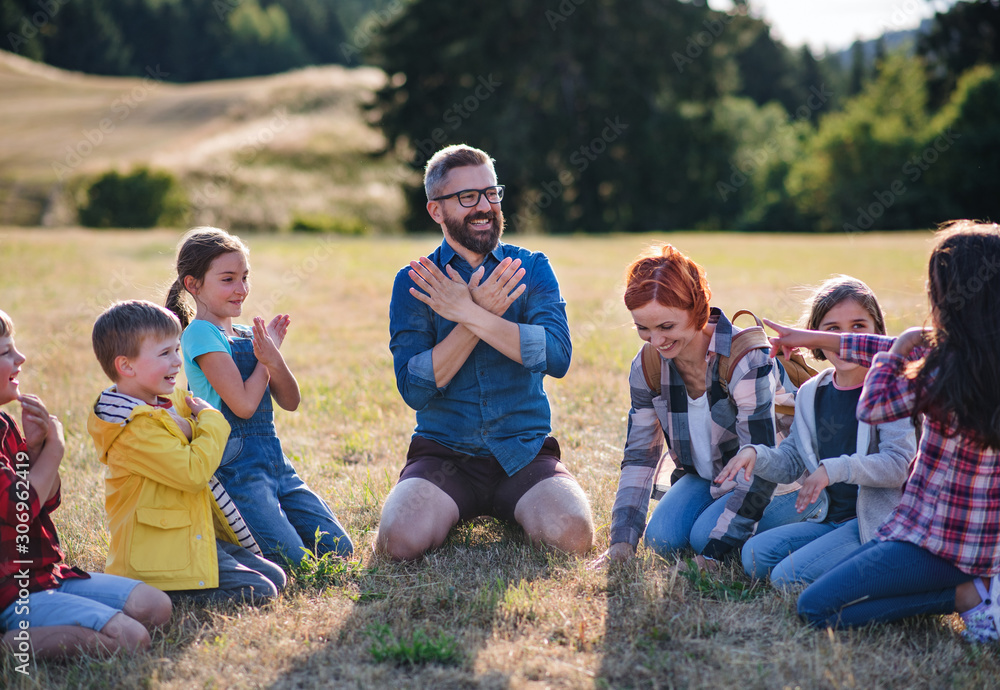Group of school children with teacher on field trip in nature, chanting. Group of school children with teacher on field trip in nature, chanting.