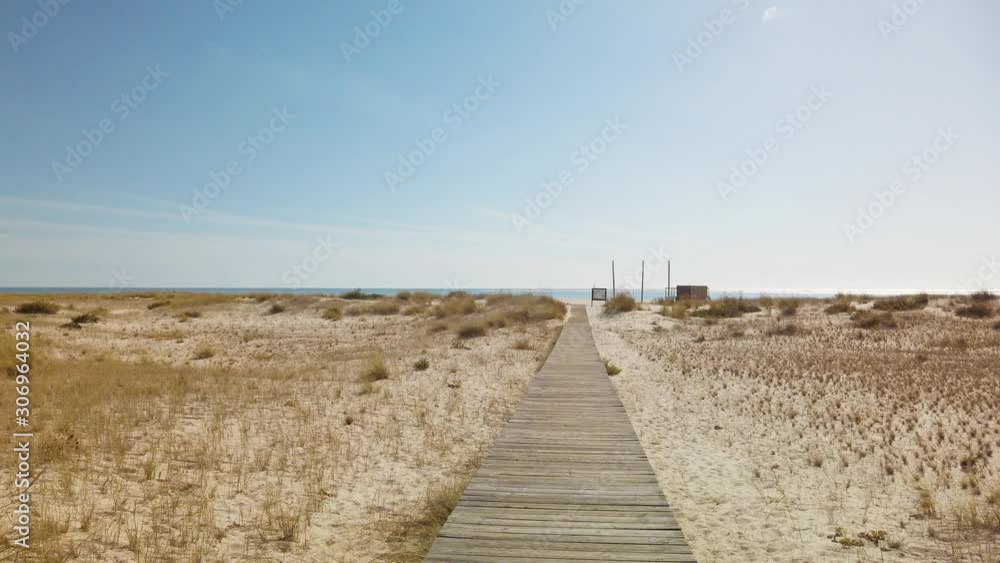 Walking on Wooden Footpath through Dunes Atlantic Ocean Beach in Portugal Walking on Wooden Footpath through Dunes Atlantic Ocean Beach in Portugal