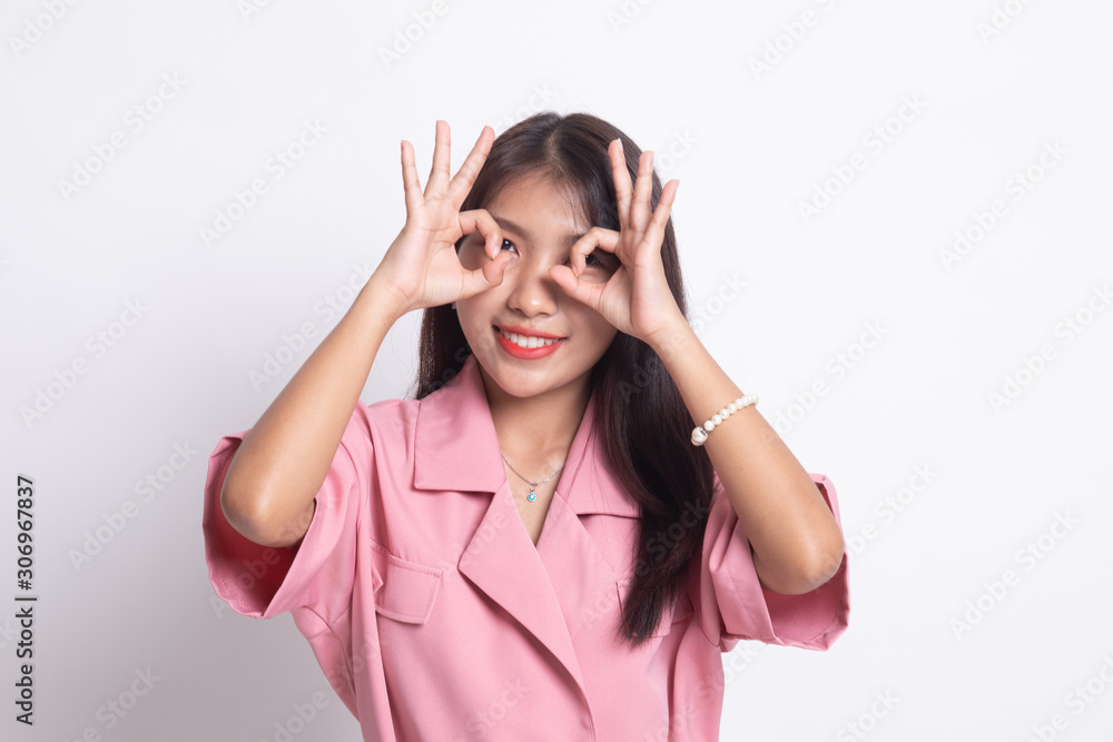 Asian woman do funny  double OK sign as glasses.