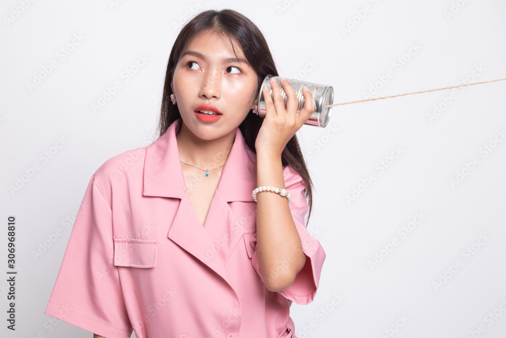 Surprised young Asian woman with tin can phone. Surprised young Asian woman with tin can phone.