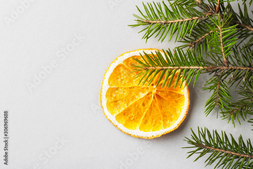 Orange chips in the shape of a Christmas decoration on a fir branch. Eco organic homemade dried orange slices, chips. Healthy snack. Close up. Top view. Copy space