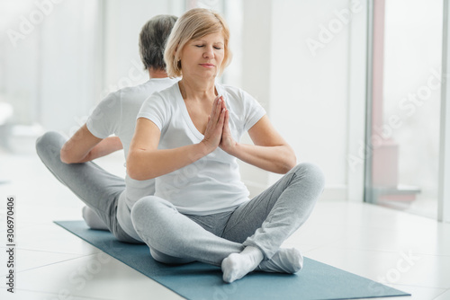 Healthy lifestyle and wellness concept. Senior couple doing yoga together.