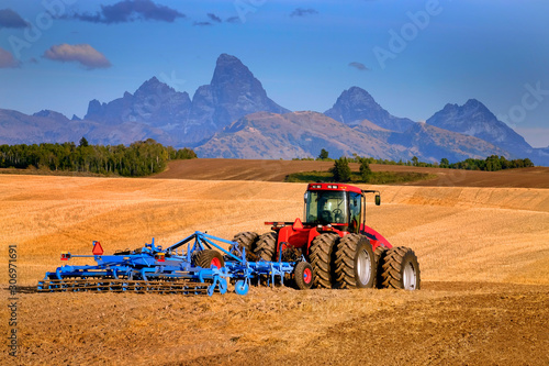 Canvas Print Tractor Farming Ground Harvesting Crops in Fall Autumn Teton Mountains Rugged