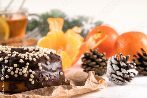 .donut, tea and tangerines and branches of a Christmas tree on a white background