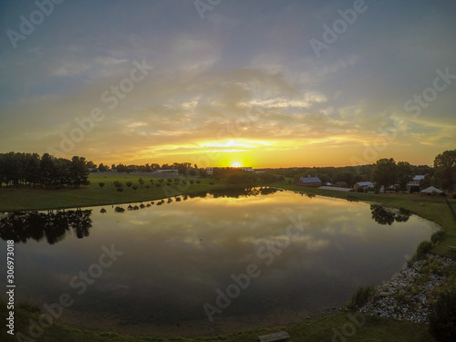 Large pond with the sky reflection at sunset as seen from an aerial drone