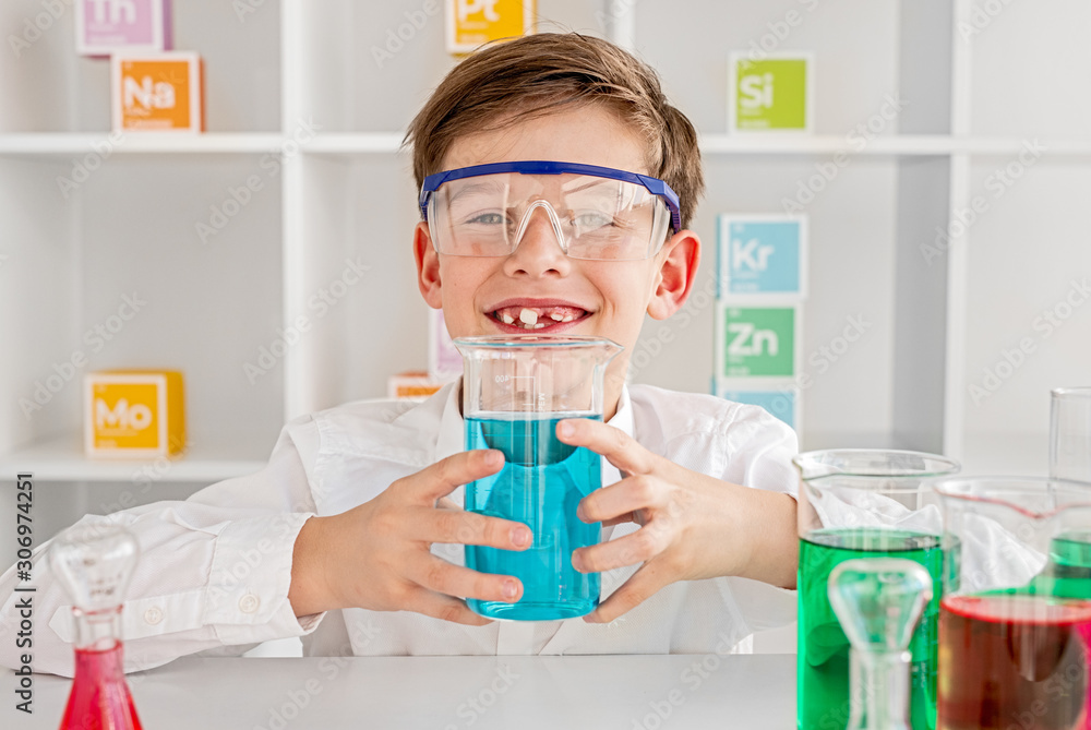 Cheerful chemist presenting flask with blue mixture Cheerful chemist presenting flask with blue mixture