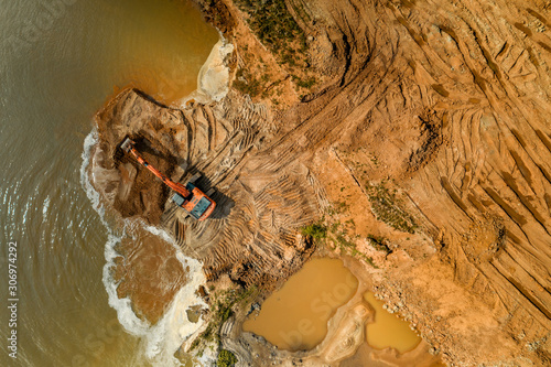 Aerial view of a working excavator in the mine. Industrial background on mining theme. Drone shot