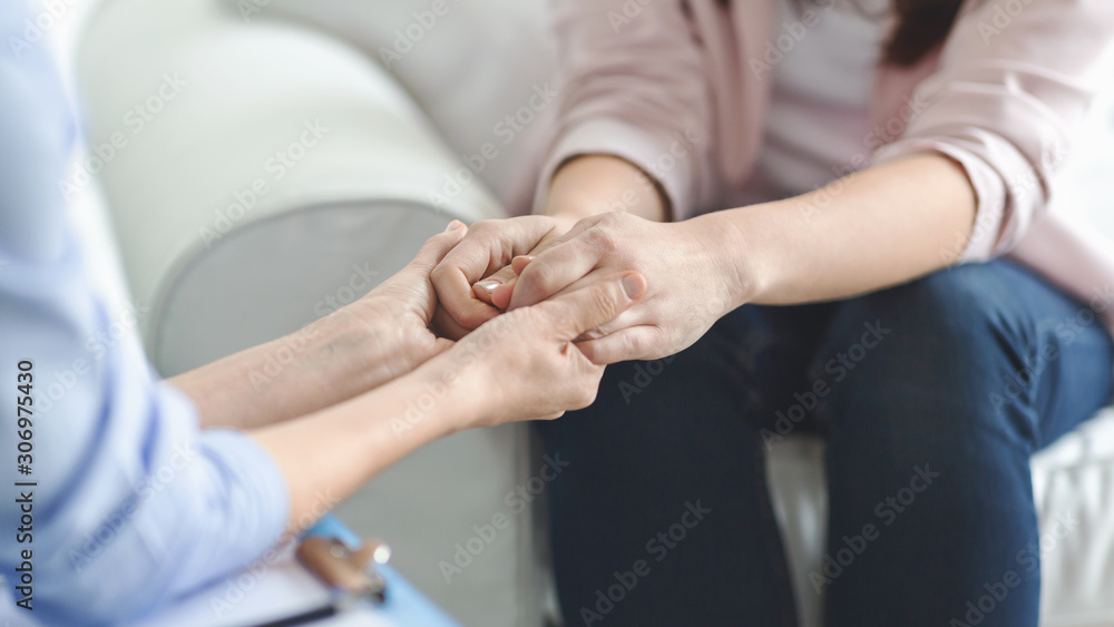 Doctor, psychologist, therapist holding female patient hands