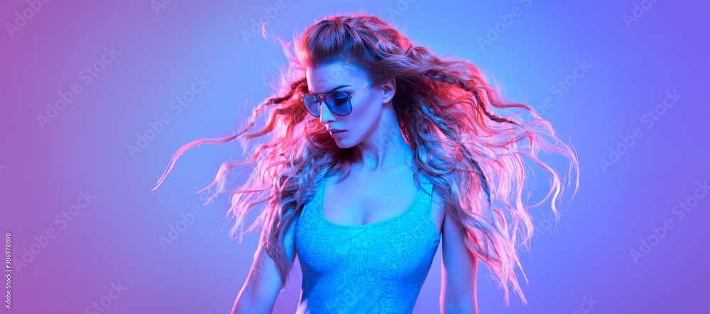Fototapeta High Fashion. Party disco girl with pink neon hairstyle dance. Sensual beautiful woman in Colorful uv Light. Vibrant fashionable creative Style. Night Club music vibes, dancing, neon lighting portrait
