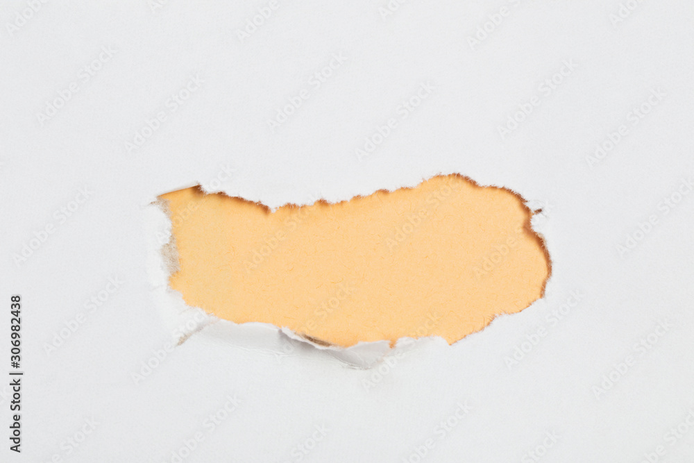 hole in white paper with colored paper backing hole in white paper with colored paper backing