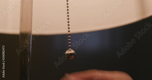 Woman's hand turn on the lamp