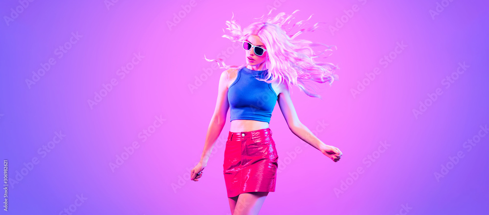 Adorable Fashion woman in party outfit dance, Trendy neon light hairstyle.  Night club music vibes, gel filter. Excited shapely beautiful sexy girl  dancing. Pop Art fashionable creative neon color. foto de Stock