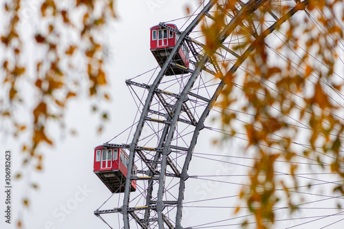 Canvas Print Gondolas of Wiener Riesenrad behind orange colored leaves