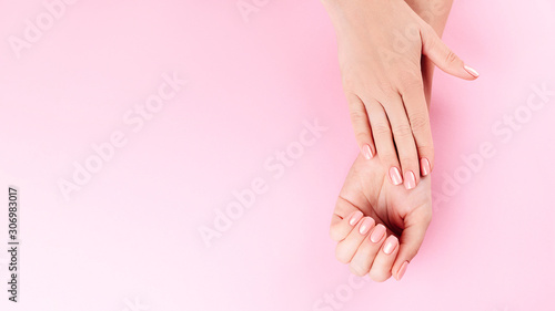 Beautiful Woman Hands on pink backgrounda. Spa and Manicure concept. Female hands with pink manicure. Soft skin skincare concept. Beauty nails.