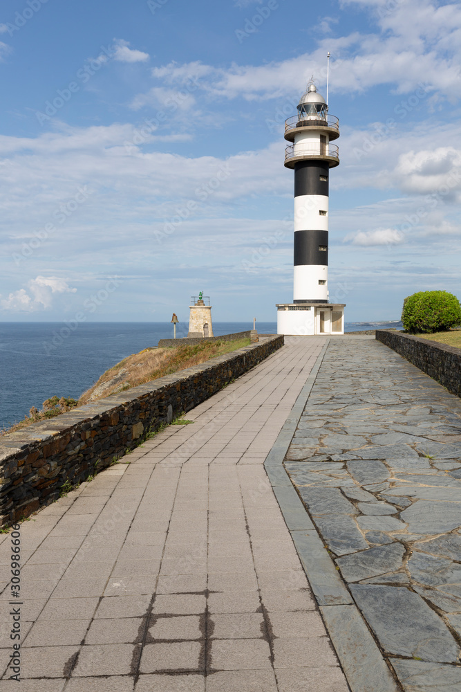 Faro de franjas blancas y negras situado en el Cabo San Agustín en Ortiguera con una espectacular vista del mar. Asturias, España.