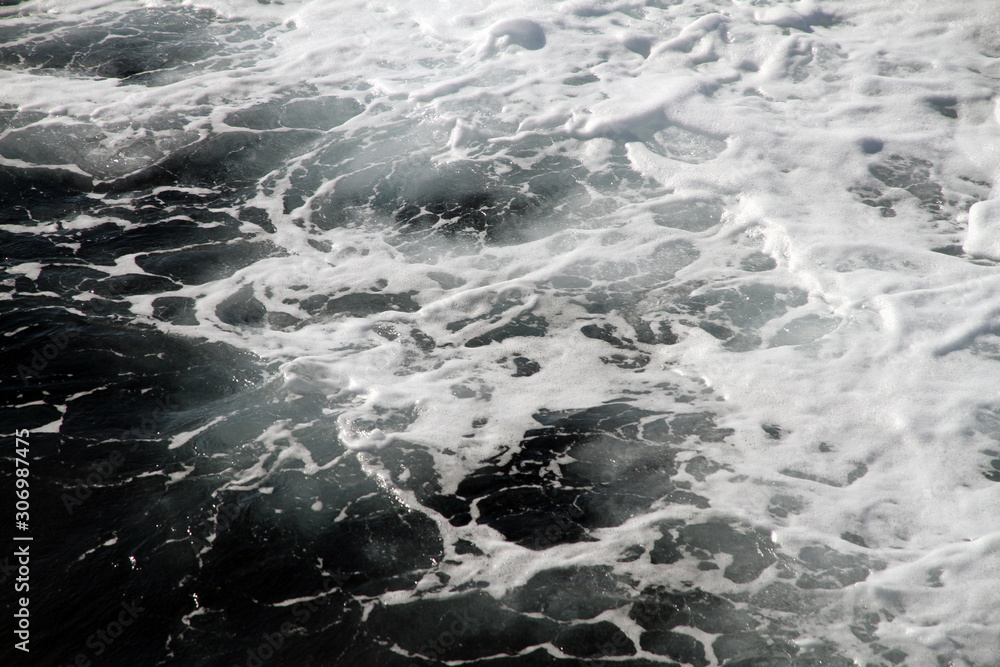 Weisser Schaum und Wellen auf der Wasseroberfläche im Meer. Gischt am