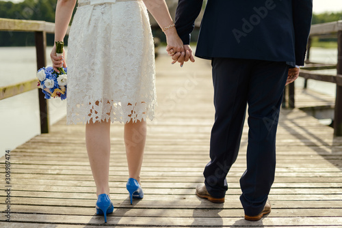 Bride and groom at a photo session in the nature. Lake and pier © Andrzej Wilusz