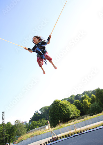 Ein kleines Mädchen springt Bungee auf einem Trampolin