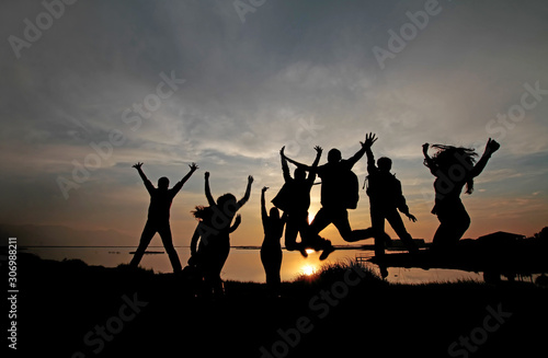 People in silhouette at sunset.