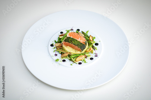 Salmon with Dill  and Sauteed Vegetables served on white plate over white texture background. Top view, copy space. Plating, fine dining