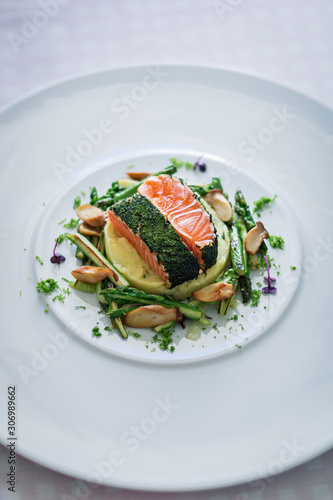 Salmon with Dill  and Sauteed Vegetables served on white plate over white texture background. Top view, copy space. Plating, fine dining
