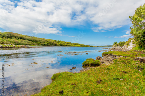 Estuary surrounded by hills with green vegetation, spring day with a blue sky and abundant clouds around Clifden, provincia de Connacht, Ireland