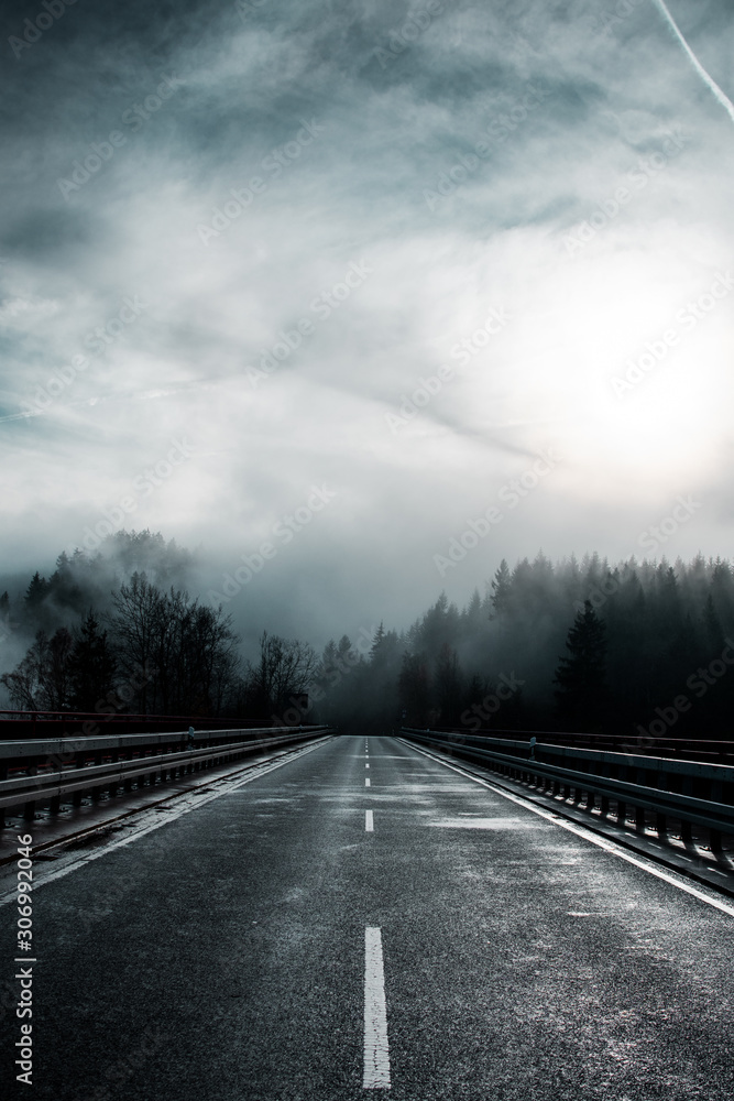 Low hanging clouds and fog in the mountains top of pine trees on a moody dark winter day with contrastful cold color tones. National Park Harz Mountains in Germany Low hanging clouds and fog in the mountains top of pine trees on a moody dark winter day with contrastful cold color tones. National Park Harz Mountains in Germany