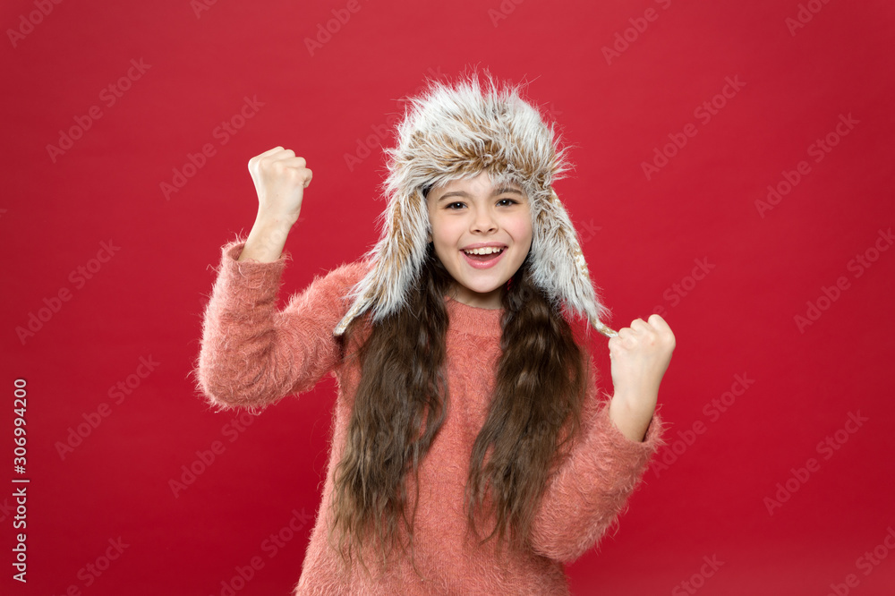 Fashion model wear fur hat red background. warm kid fashion. seasonal health care. holiday activity outdoor. happy little girl in earflap hat. small child ready for winter. ready for having fun Fashion model wear fur hat red background. warm kid fashion. seasonal health care. holiday activity outdoor. happy little girl in earflap hat. small child ready for winter. ready for having fun